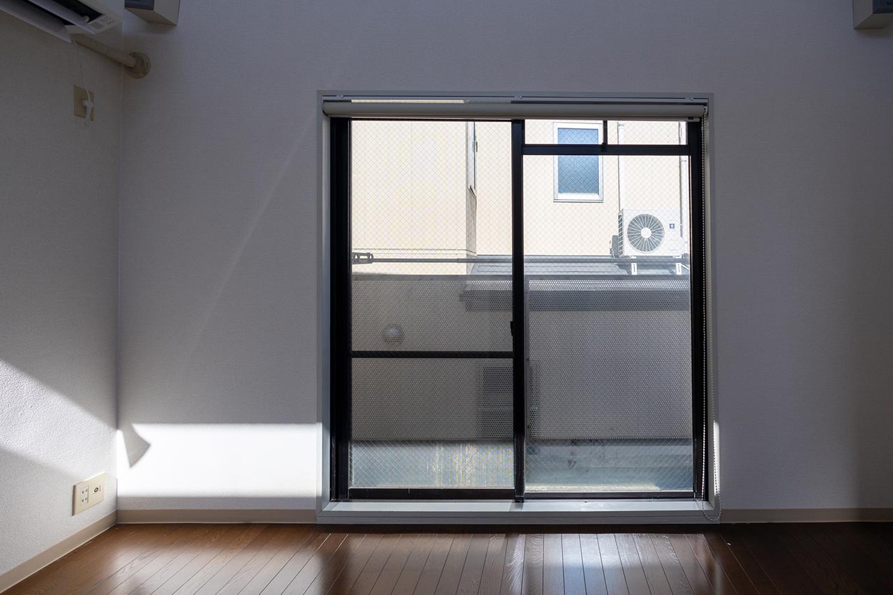 掃き出し窓から隣の建物が見える部屋のイメージ画像