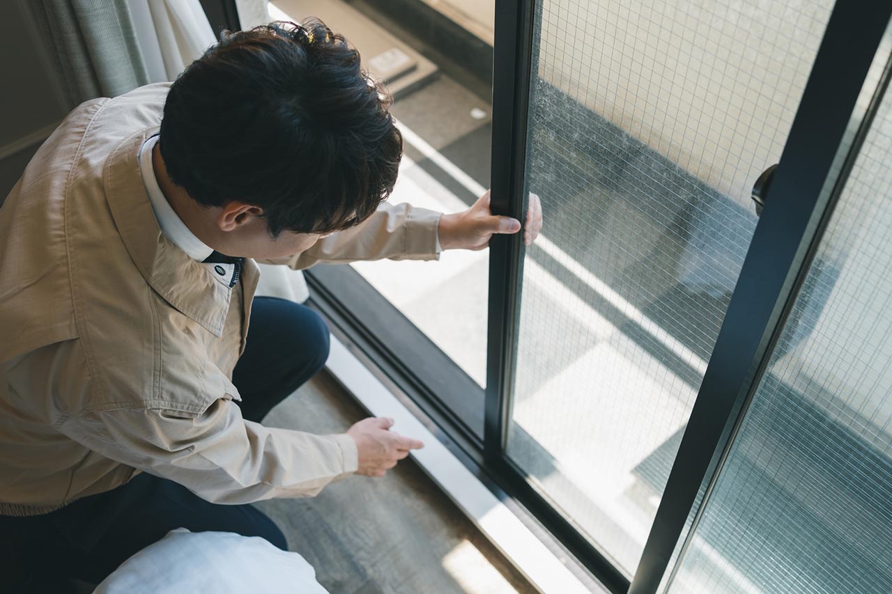 掃き出し窓を点検する業者のイメージ画像